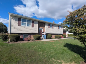 Happy homebuyers in front of a Gettysburg home for sale with Christine Dell, Associate Broker at Re/Max Quality Service, Inc