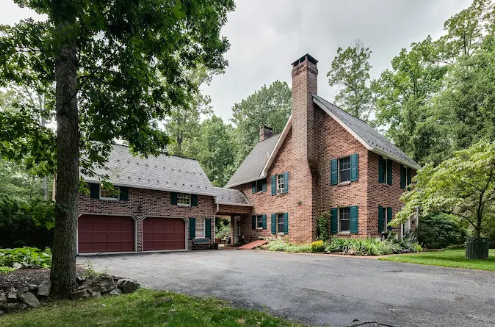 Realtor Hanover, PA Christine Dell showing a spacious brick home with a garage and landscaped yard in Hanover